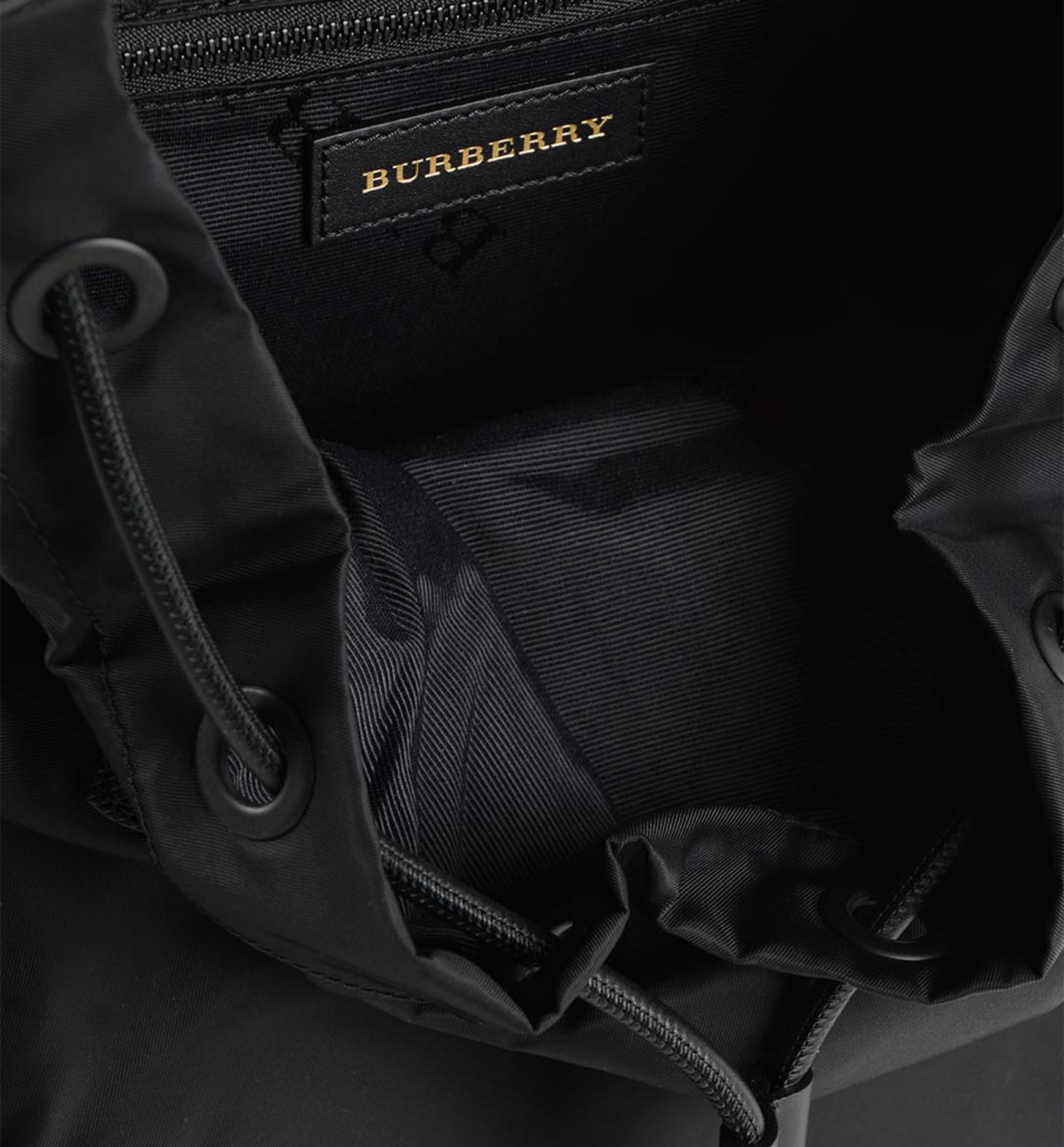 Burberry Rucksack Nylon Backpack – Black, Leather Trim, Zip Pockets
תיק גב Burberry Rucksack ניילון שחור – חיתומי עור וכיסים עם רוכסן